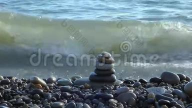 禅石堆在海滩上，后面有海浪。